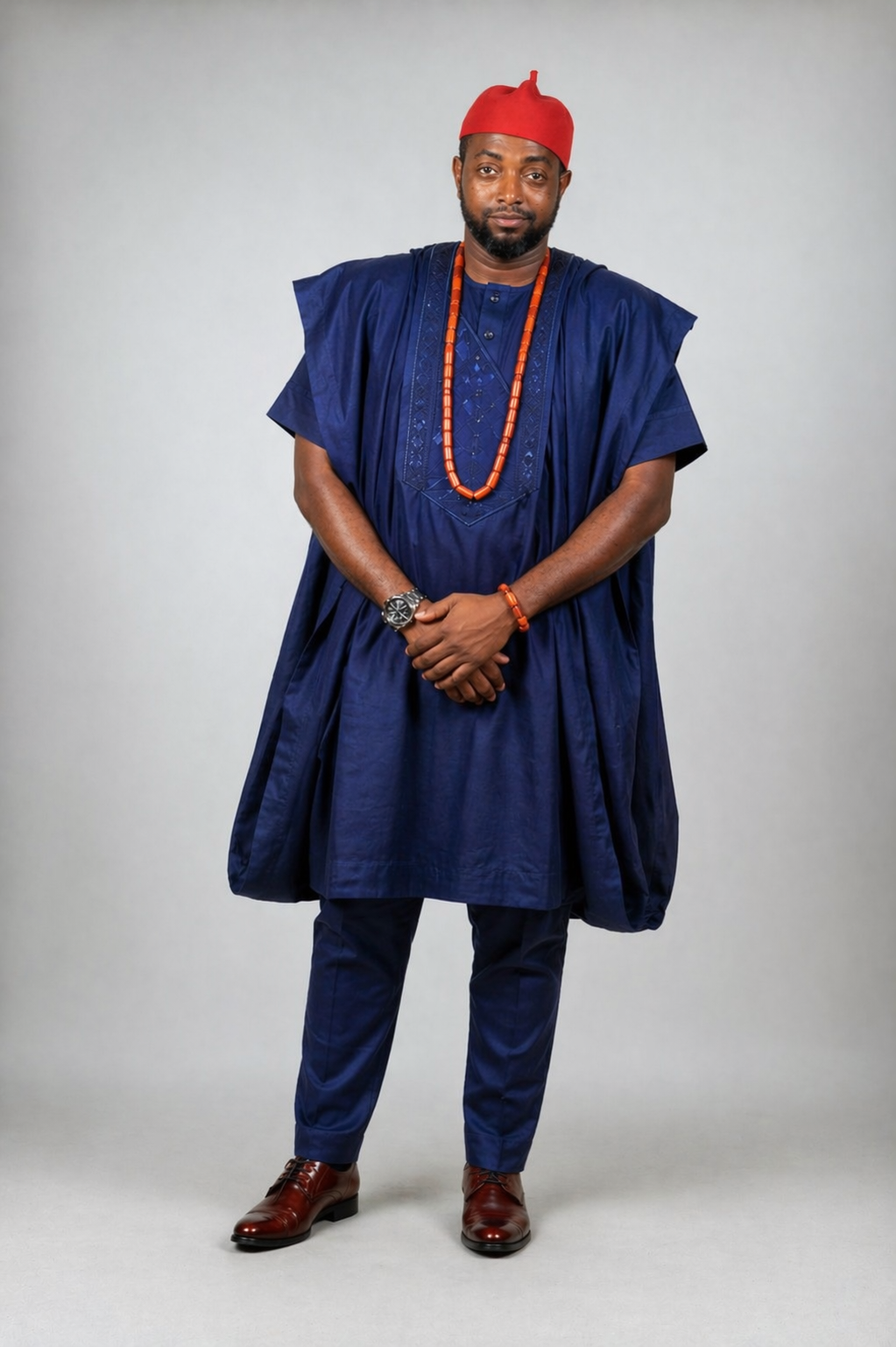 Chefiyke — navy blue agbada, red cap, controlled authority